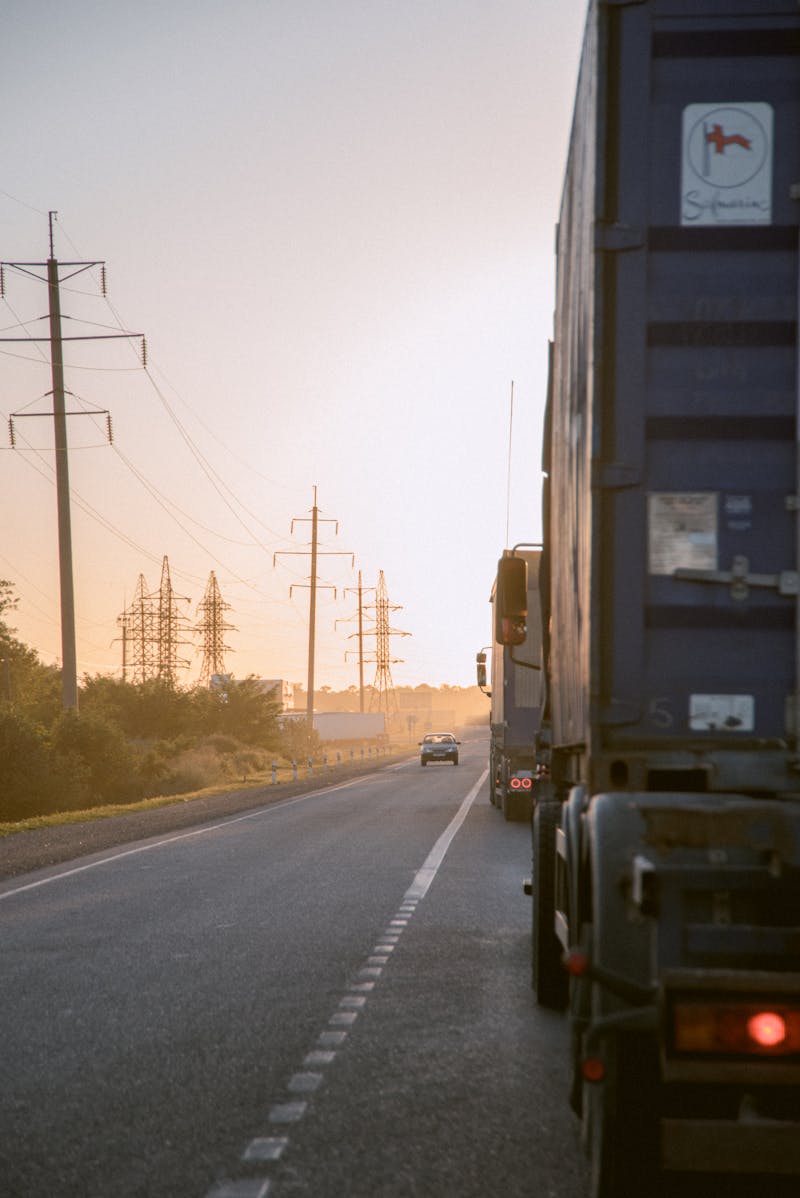 Elektrische vrachtwagens op een snelwegcorridor bij zonsondergang