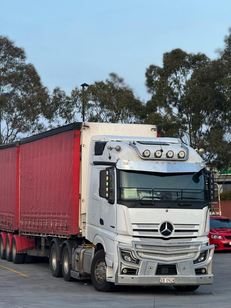Semi-truck op een logistieke hub als illustratie van laden op snelwegcorridors voor zware elektrische vrachtwagens