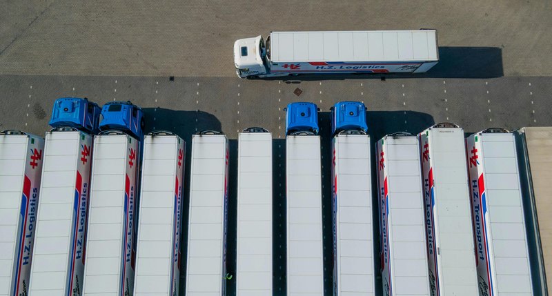 Aerial view van meerdere trucks op een logistieke parkeerlocatie als illustratie van corridorcapaciteit en wachtrisico bij publiek laden
