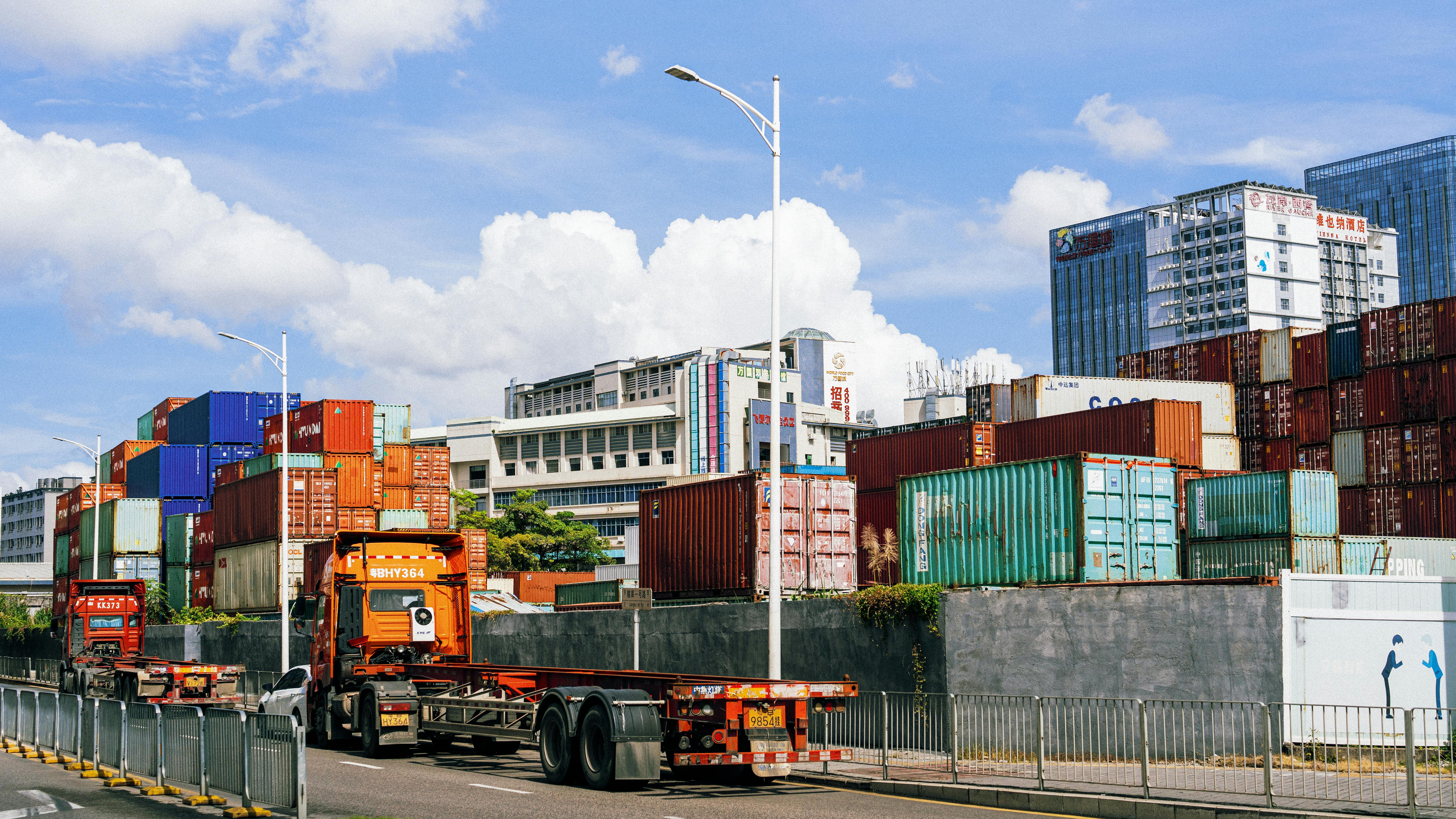Containertruck langs logistieke containers als illustratie van corridorladen en megawatt charging voor elektrische trucks
