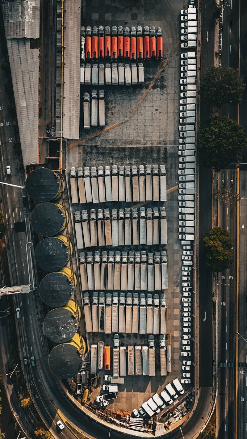 Luchtfoto van een groot logistiek depot met vrachtwagens als illustratie van laadplanning, voertuigrotatie en depotoperaties voor elektrische trucks