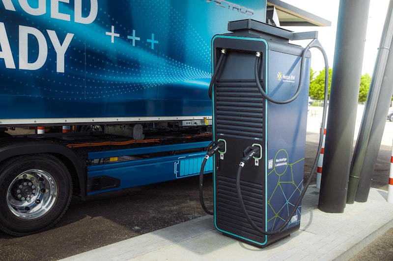 Blauwe Europese cab-over truck bij laadinfrastructuur als illustratie van elektrische linehaul, laadstops en corridorplanning in Europa
