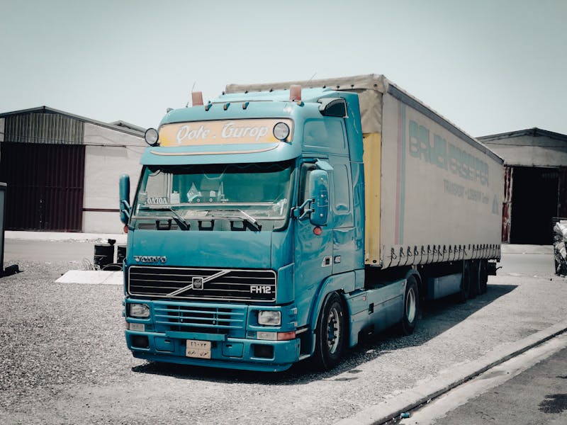 Europese trekker bij warehouse als illustratie van publieke truck charging hubs, corridorlogistiek en de opschaling van elektrische vrachtwagens
