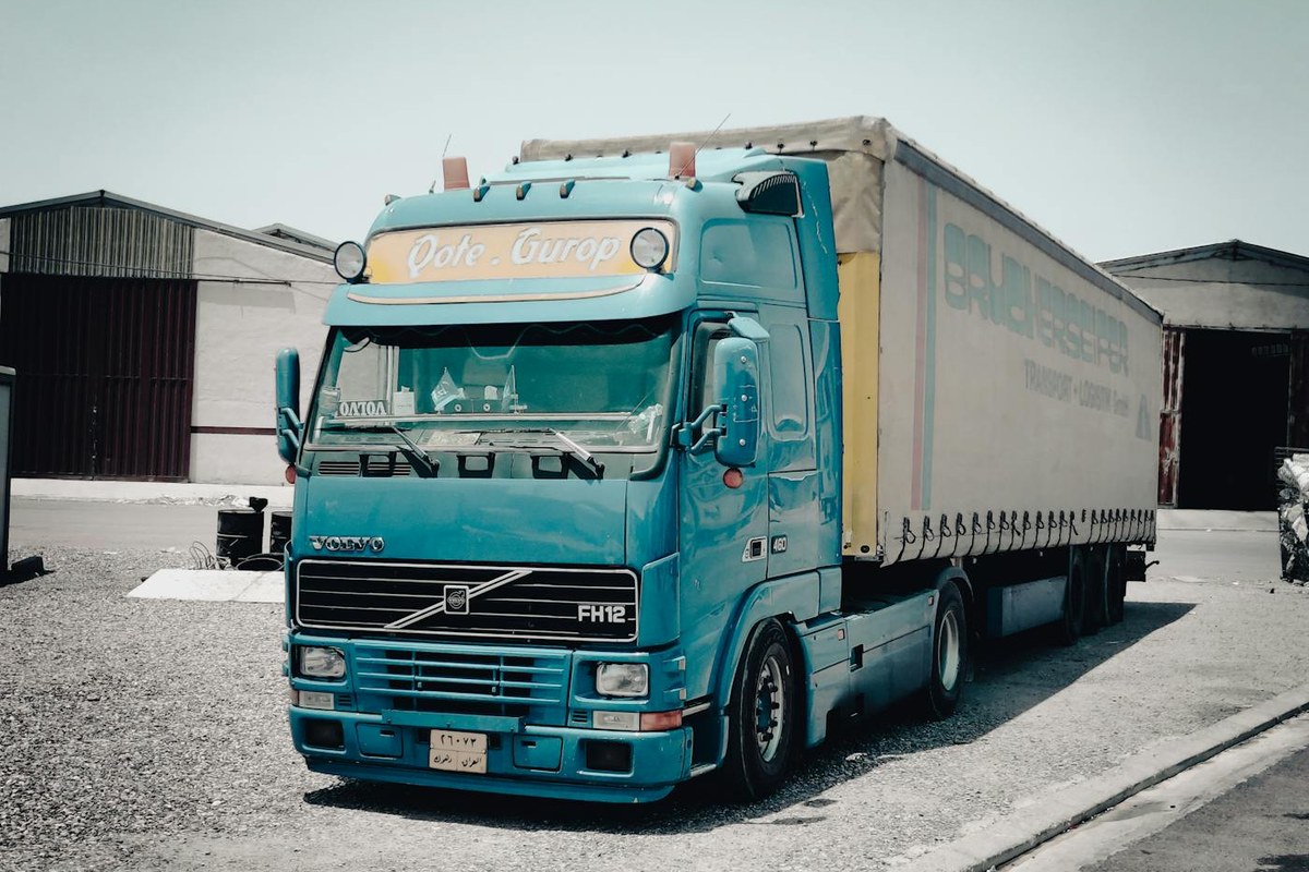 Europese Volvo vrachtwagen bij een warehouse als illustratie van laadplanning, piekverbruik en gecontracteerd transportvermogen voor een truckdepot