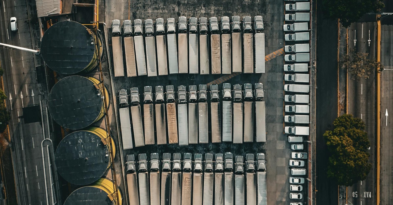 Luchtfoto van een truckdepot met meerdere vrachtwagens als illustratie van congestiemanagement, flexibel vermogen en laadsturing op locatieniveau