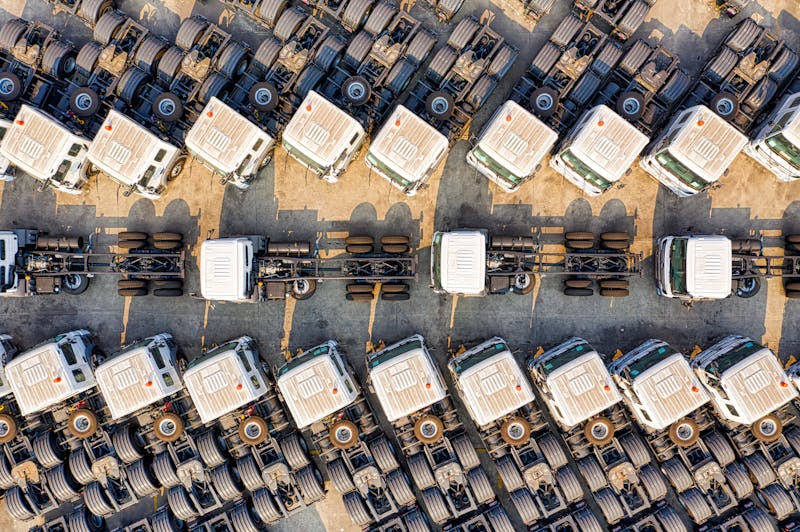 Luchtfoto van meerdere vrachtwagens op een logistiek depot als illustratie van truckladen, netcongestie en de keuze tussen meten, rekenen en investeren