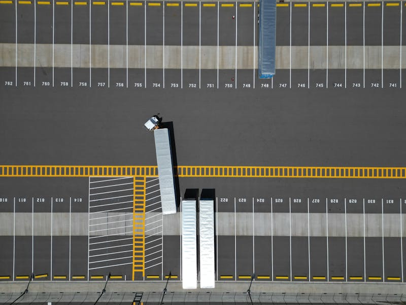 Luchtfoto van een truckparkeerterrein met trekkers en trailers als illustratie van depotcapaciteit, laadsturing en flexibiliteit bij netcongestie