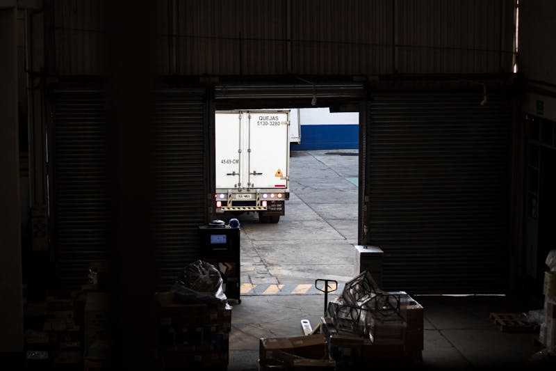 Distributietruck bij een warehouse loading dock als illustratie van strakke tijdvensters, laaddiscipline en operationele afhankelijkheid in een truckdepot