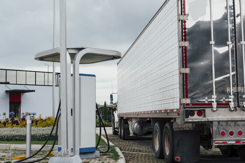 Vrachtwagen naast een snellader als illustratie van laadvensters, routeplanning en elektrische linehaul