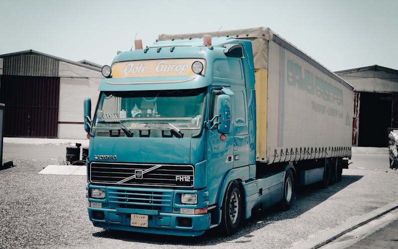 Cab-over vrachtwagen bij een warehouse als illustratie van elektrische truckplanning en depotlogistiek