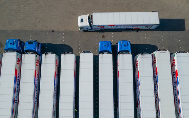 Rij geparkeerde vrachtwagens op een depot als illustratie van gefaseerde laadinfra en vlootplanning