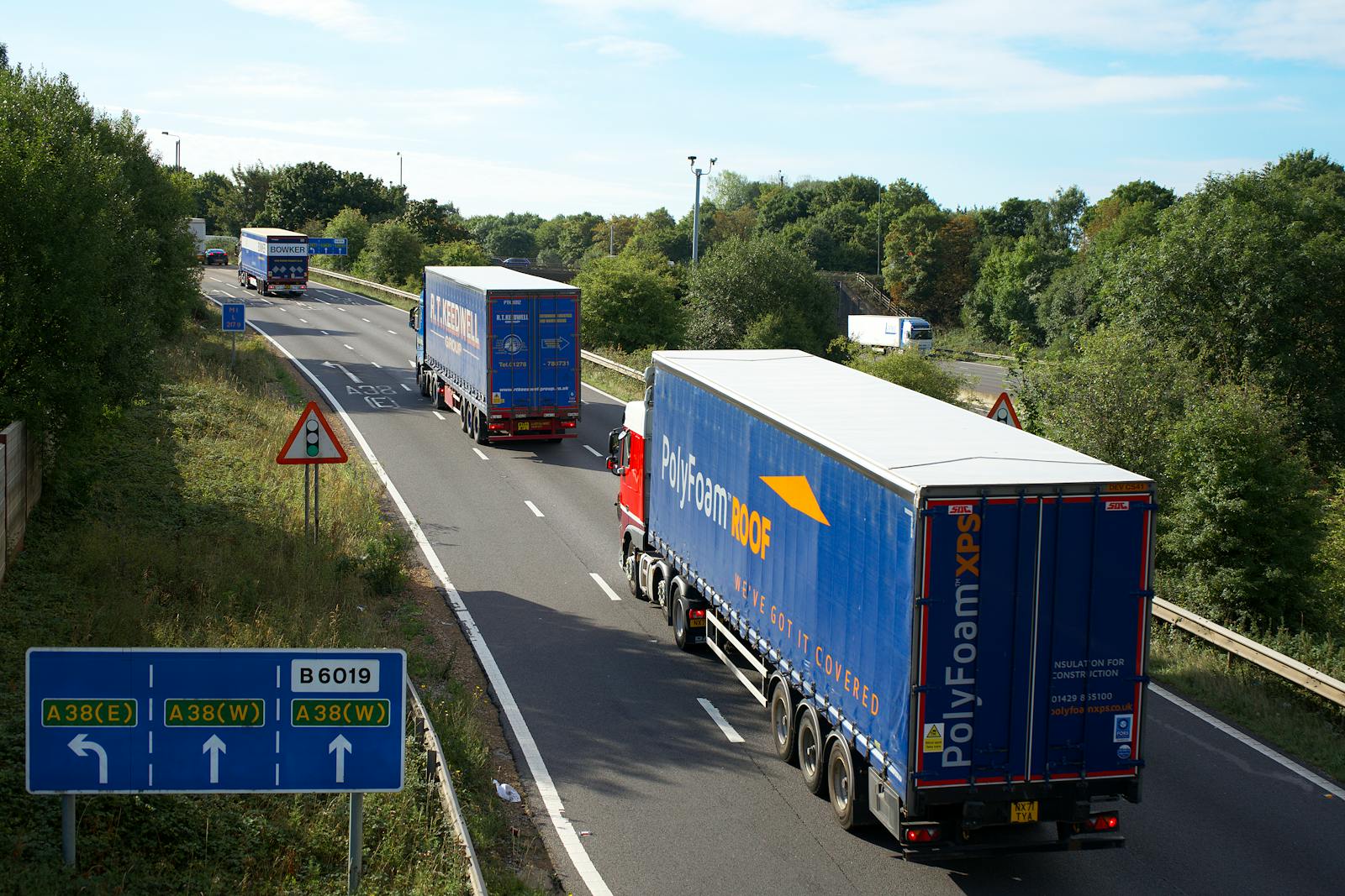 Vrachtwagens op een hoofdweg als illustratie van elektrische truckroutes, kilometers en vrachtwagenheffing