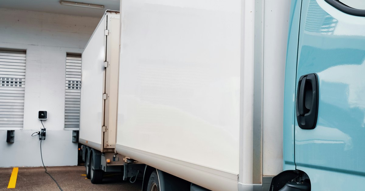 Elektrische distributietruck aan een laadpunt bij een dock als voorbeeld van Plug & Charge op een truckdepot