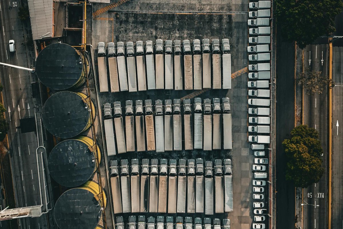 Luchtfoto van een logistiek depot met rijen trucks als voorbeeld van laadplanning, autorisatie en kostenplaatsen