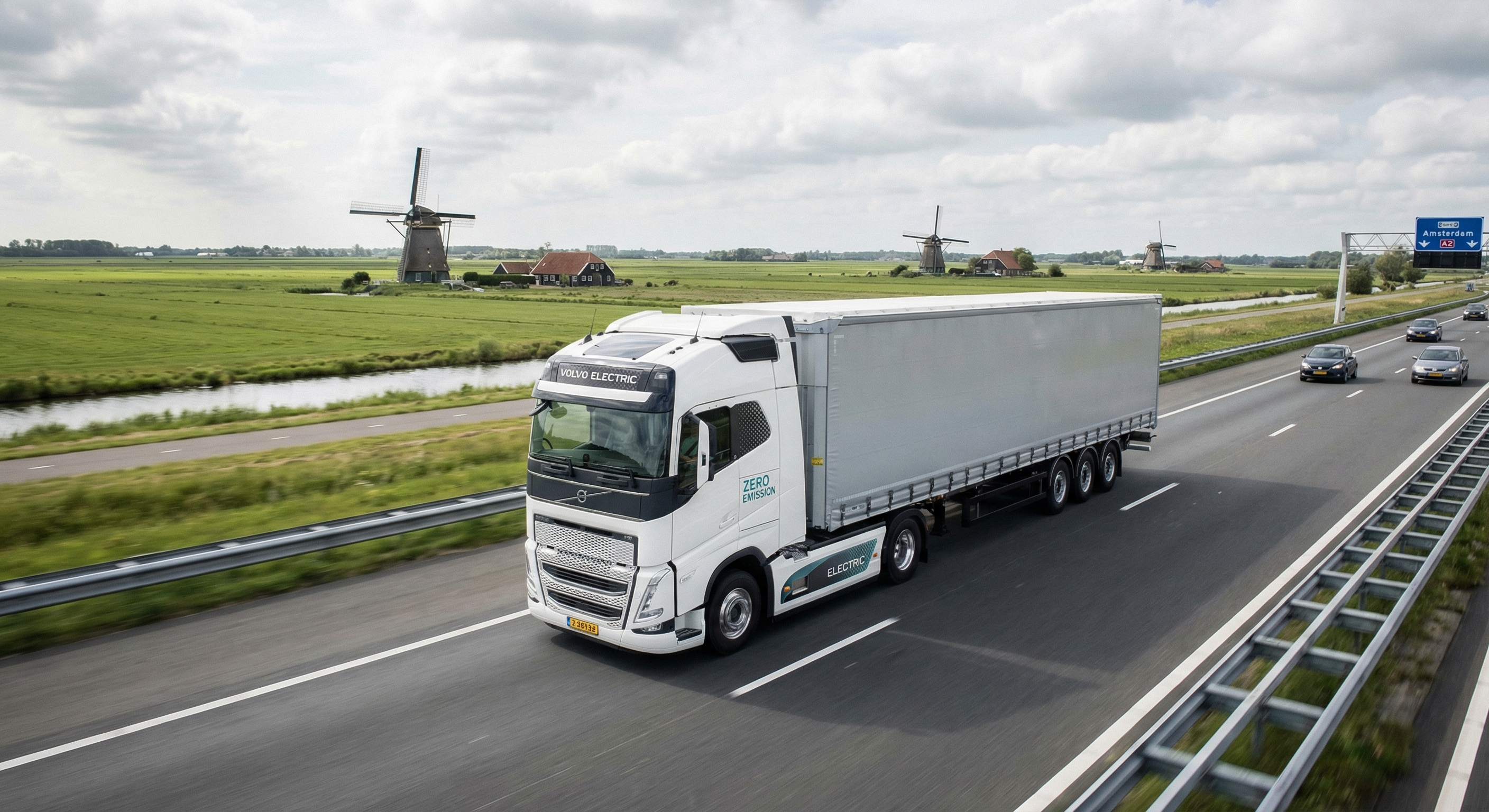 Elektrische vrachtwagen rijdt over een Nederlandse snelweg met windmolens op de achtergrond